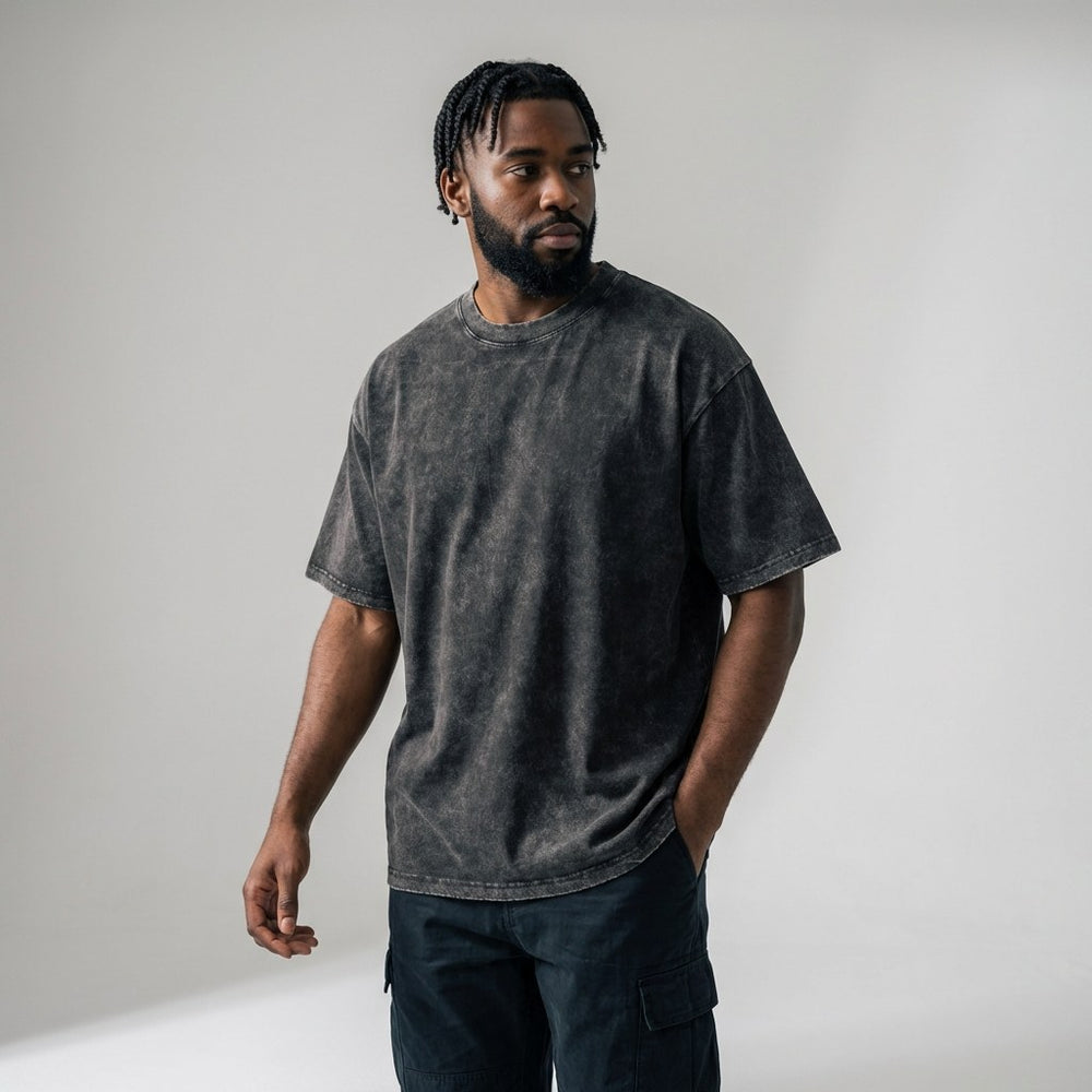Male model wearing custom dark grey acid wash oversized t-shirt, 250gsm heavyweight cotton streetwear fit.