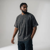Male model wearing custom dark grey acid wash oversized t-shirt, 250gsm heavyweight cotton streetwear fit.