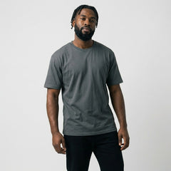 Front view of a male model standing in a charcoal grey blank t-shirt, perfect mockup base for personal brand merchandise and embroidery