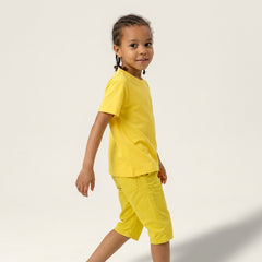 Side profile of a young boy model wearing a plain yellow t-shirt and matching shorts, ideal for custom youth team apparel and personal brand mockups