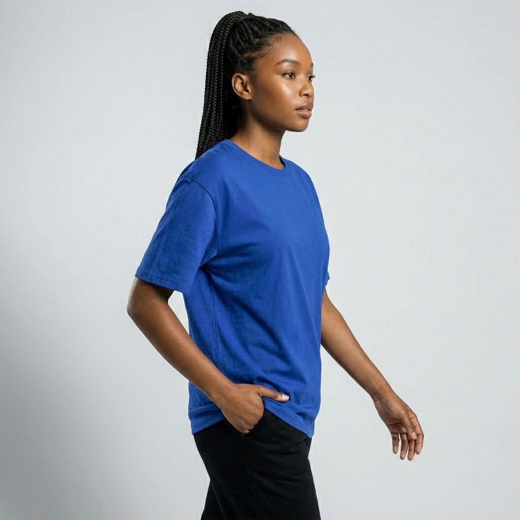 Side view of a female model wearing a blank royal blue crew neck t-shirt, ideal for custom team apparel and screen printing